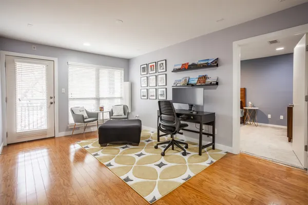 a living room with furniture and a wooden floor