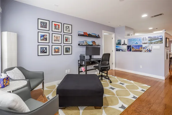 a living room with furniture and painting on the wall