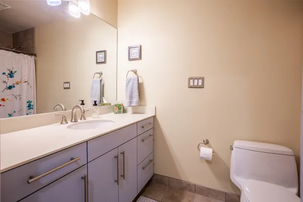 a bathroom with a granite countertop toilet sink and mirror