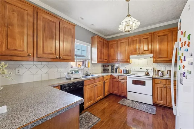 a kitchen with stainless steel appliances granite countertop a stove a sink dishwasher and a refrigerator
