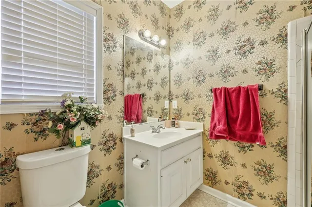 a bathroom with a sink vanity mirror and toilet