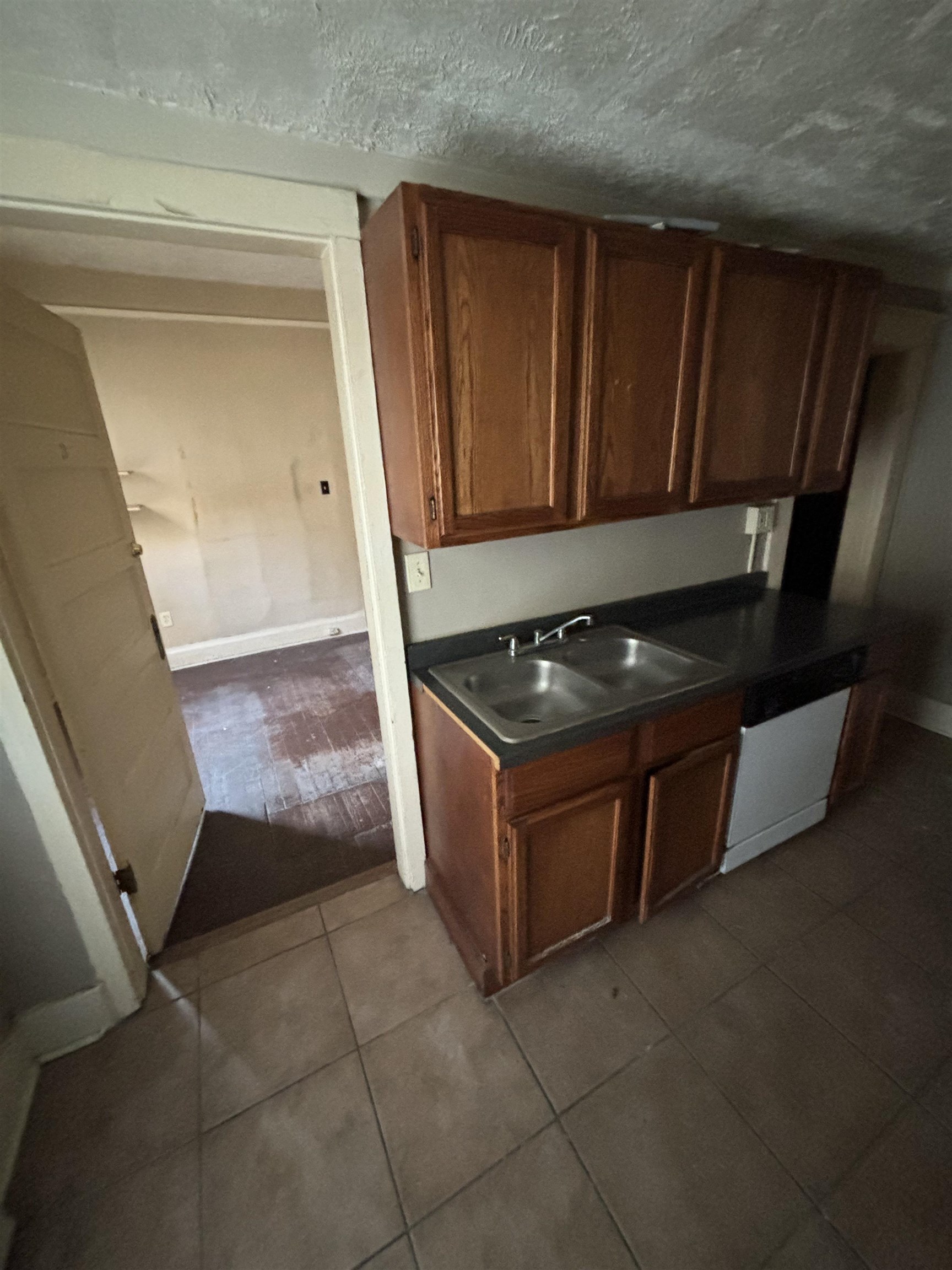 1920 Oliver Avenue Memphis, TN 38104 - Photo 19 of 19 Kitchen featuring dishwasher, a sink, dark countertops, and dark tile patterned floors