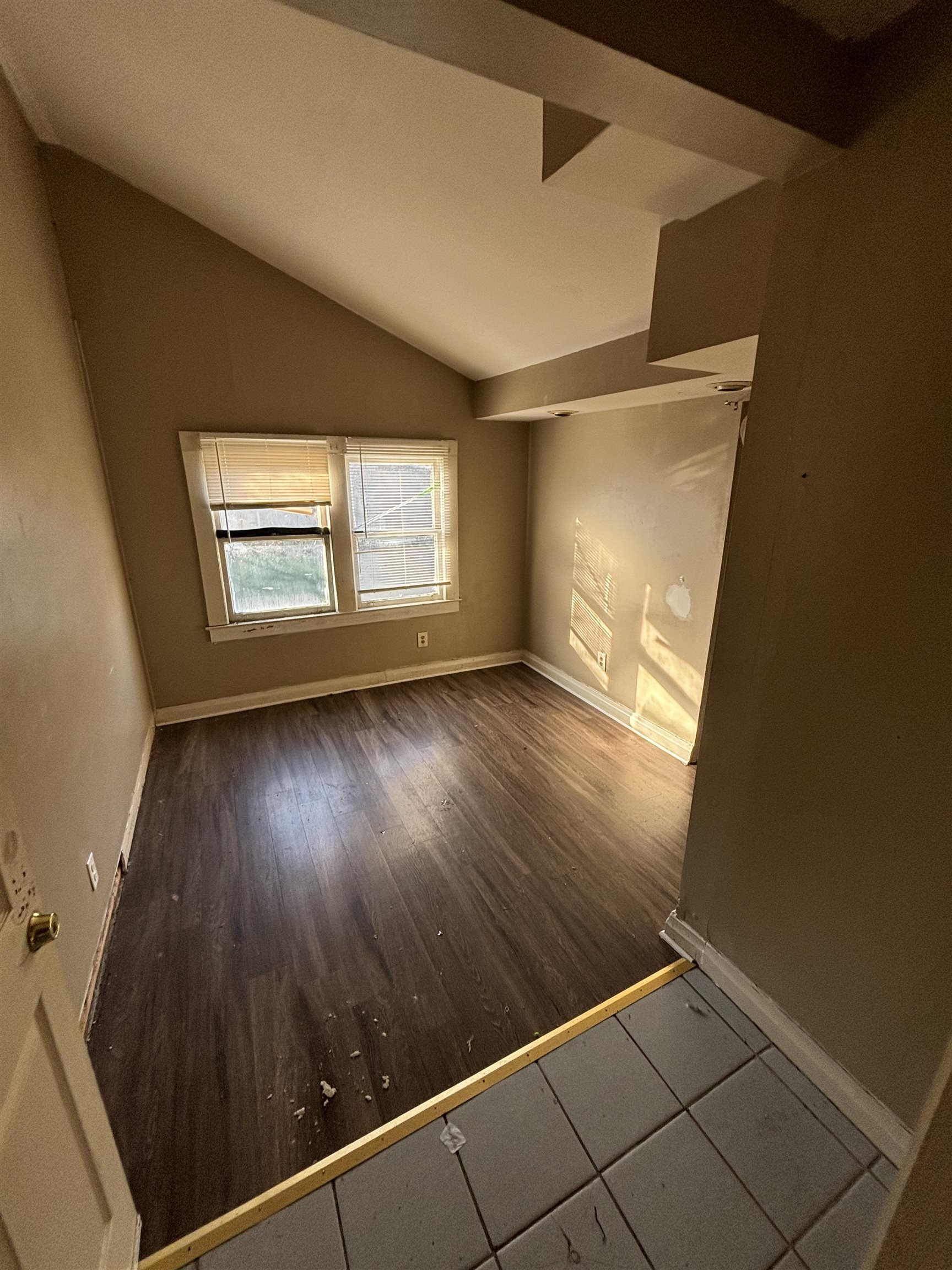 1920 Oliver Avenue Memphis, TN 38104 - Photo 9 of 19 Empty room featuring baseboards, vaulted ceiling, and wood finished floors