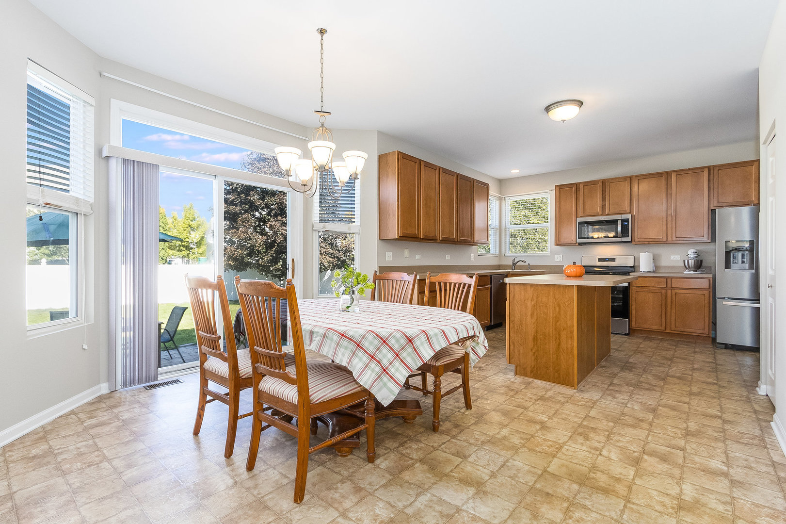3521 Legacy Drive Joliet, IL 60435 - Photo 7 of 26 a open kitchen with stainless steel appliances granite countertop a stove top oven a sink dishwasher a dining table and chairs with wooden floor