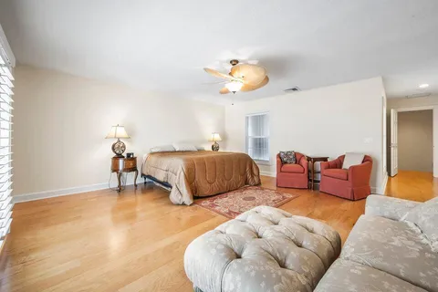 a spacious bedroom with a bed and a chandelier