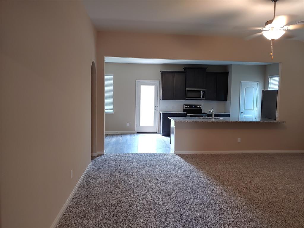 280 Moonstone Way Princeton, TX 75407 - Photo 9 of 17 Kitchen with ceiling fan, range with electric stovetop, kitchen peninsula, and light carpet