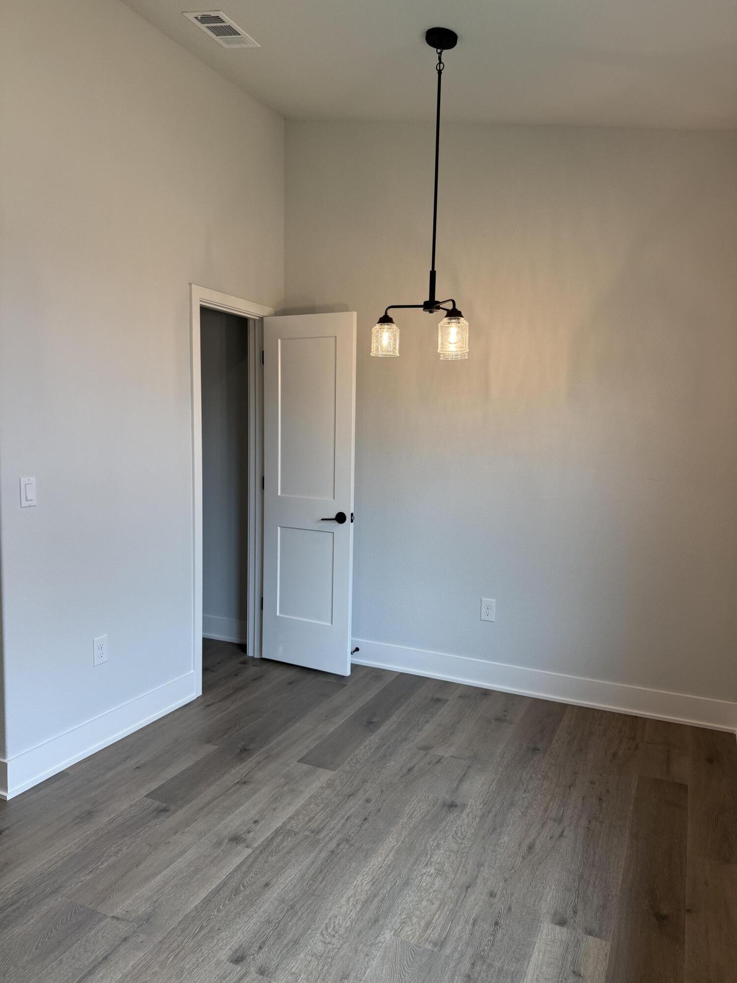 2411 Aleia Lane Crestview, FL 32536 - Photo 11 of 28 a view of an empty room with wooden floor and a window
