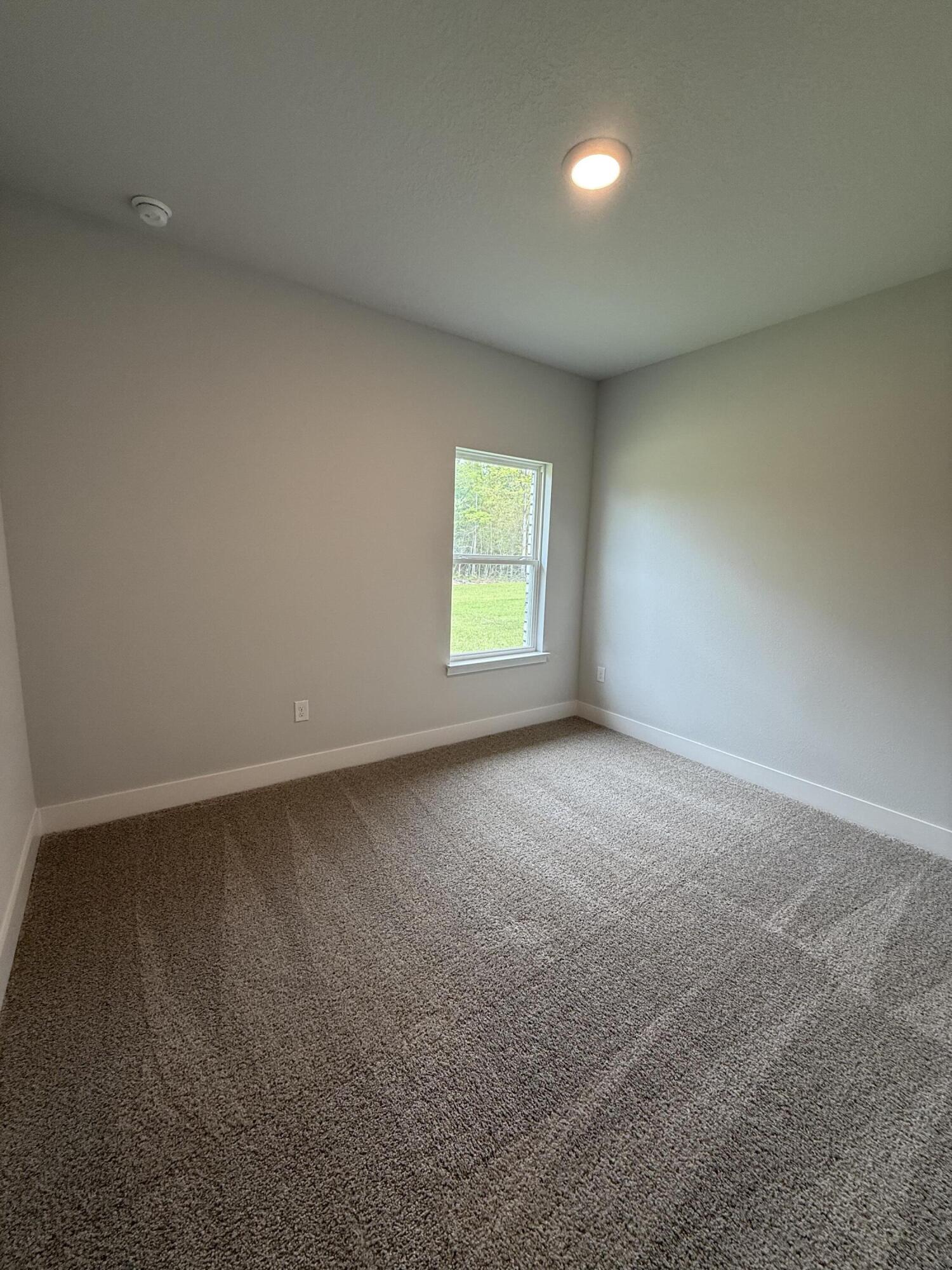 2411 Aleia Lane Crestview, FL 32536 - Photo 23 of 28 a view of an empty room with a window and a kitchen