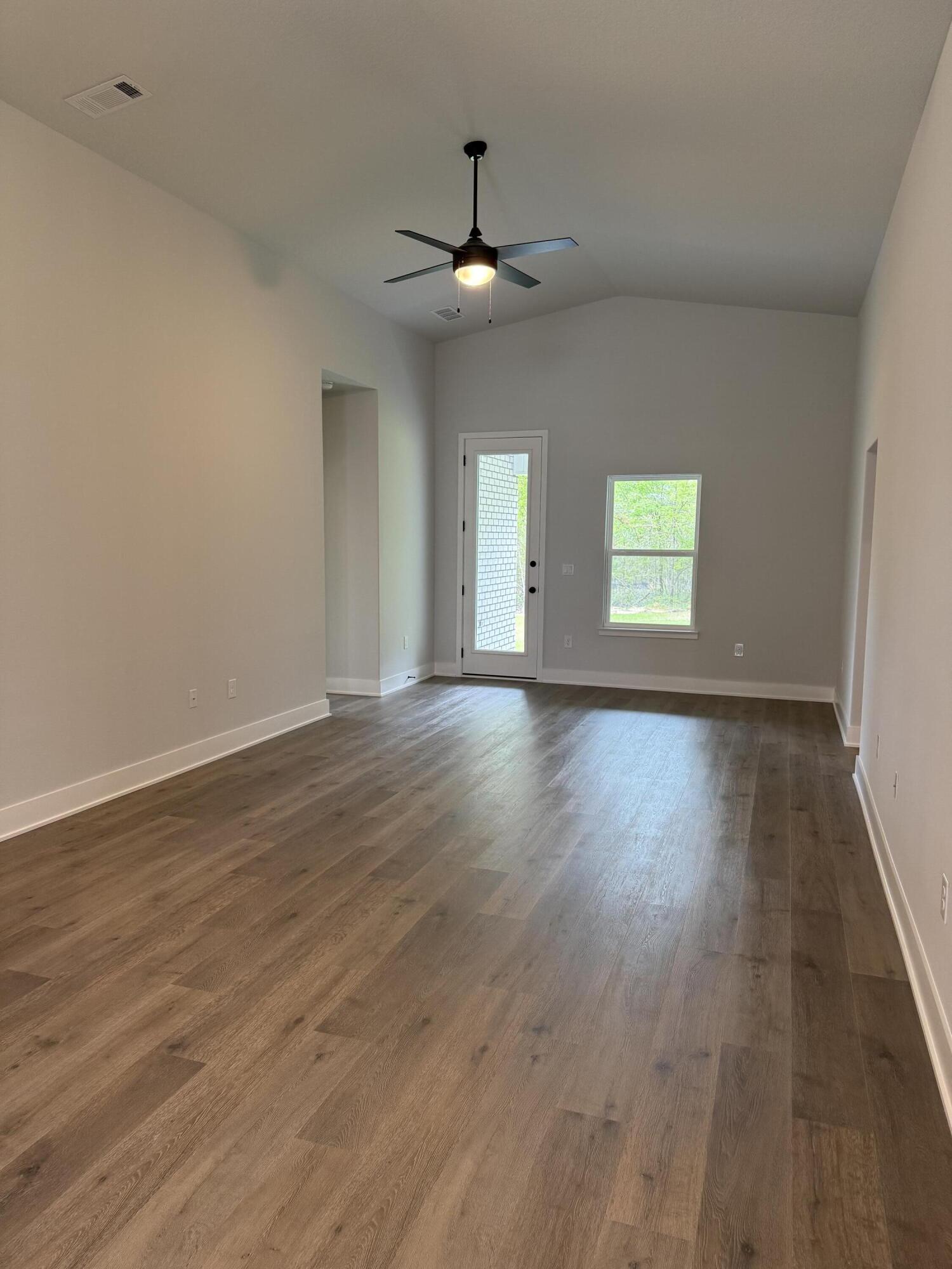 2411 Aleia Lane Crestview, FL 32536 - Photo 9 of 28 a view of an empty room with wooden floor and a window