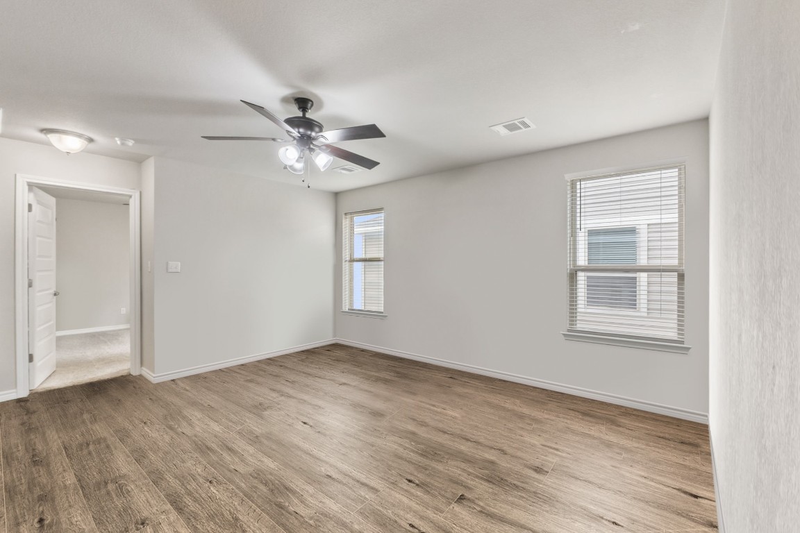 232 Syrah Court Leander, TX 78641 - Photo 22 of 37 a view of an empty room with a window and wooden floor