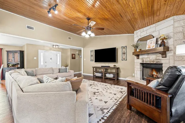 a living room with furniture a flat screen tv and a fireplace