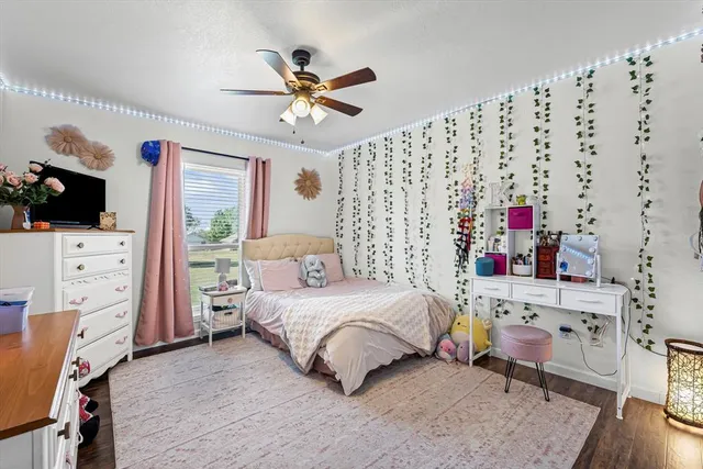 a bedroom with a bed and a flat tv screen on the dresser