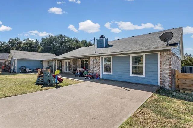 a view of a house with a patio and a yard