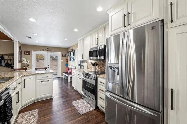 a kitchen with white cabinets and stainless steel appliances