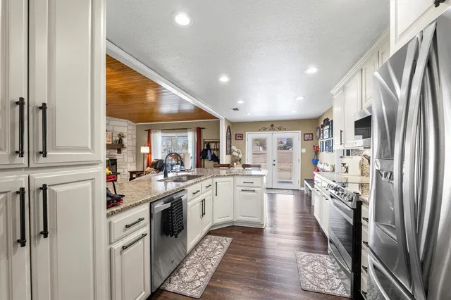 a large kitchen with granite countertop lots of counter space and stainless steel appliances