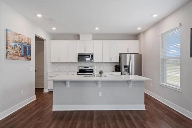 a kitchen with appliances a sink and cabinets