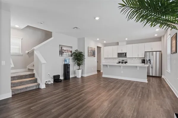 a living room with furniture and a wooden floor