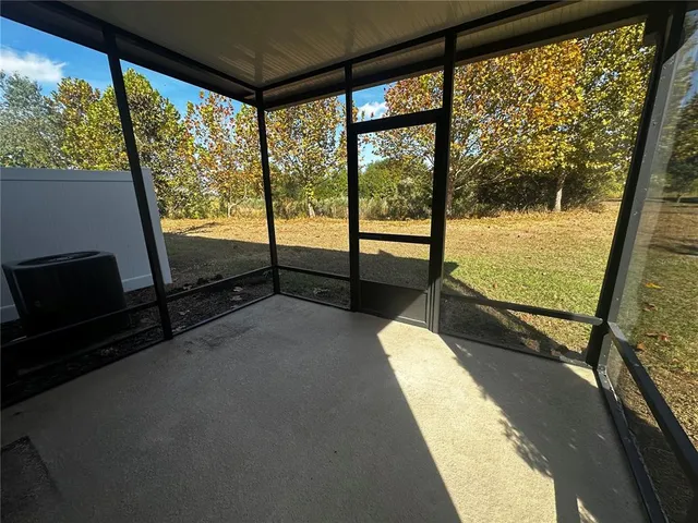 a view of a two room with wooden floor and windows