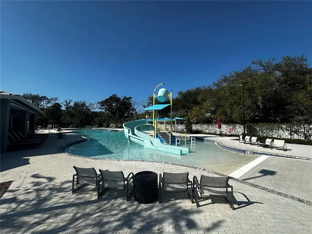 a view of swimming pool with outdoor seating and a garden