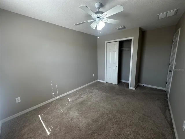 an empty room with a ceiling fan and a window