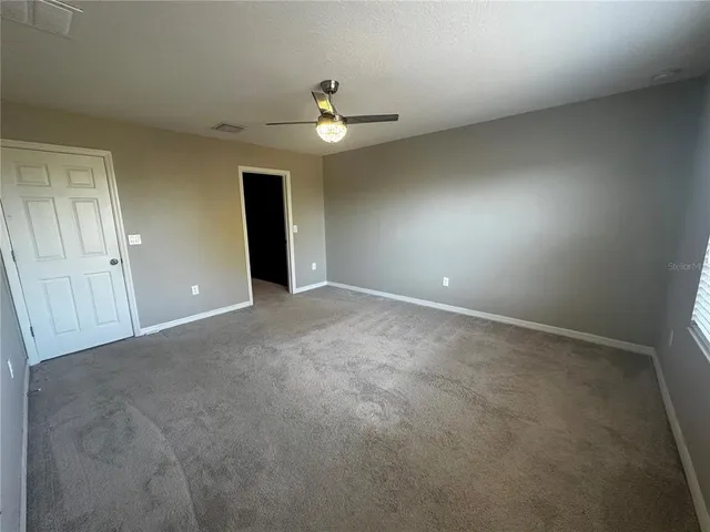 an empty room with a empty space and a ceiling fan