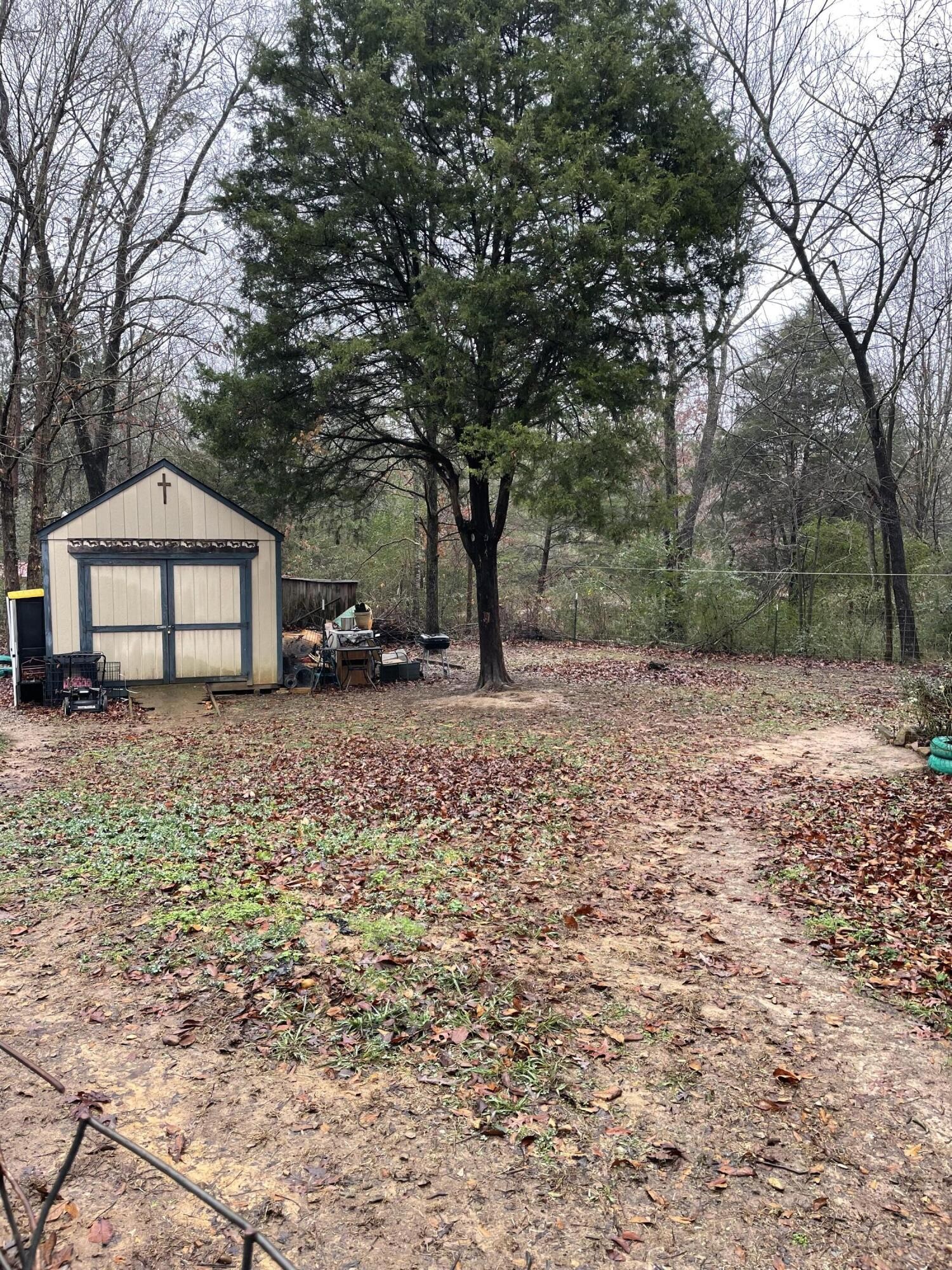 122 Haddock Lane Benton, TN 37307 - Photo 4 of 23 a front view of a house with a yard and large trees