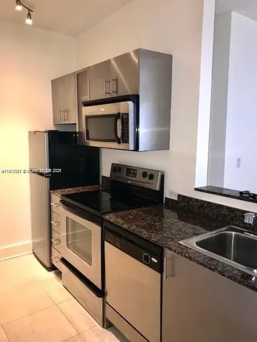 a kitchen with granite countertop a stove and a microwave