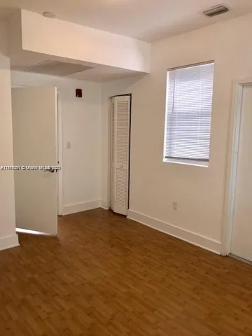 an empty room with wooden floor and closet
