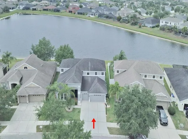 an aerial view of residential houses with outdoor space and lake view