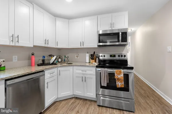 a kitchen with stainless steel appliances granite countertop a stove a microwave and cabinets