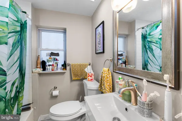 a bathroom with a sink a toilet and a window