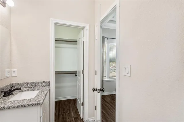 a bathroom with a granite countertop sink and a mirror