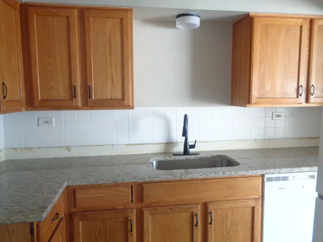 a kitchen with granite countertop cabinets sink and window