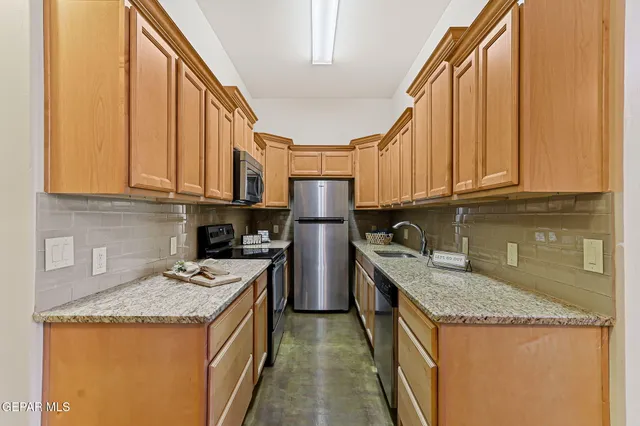 a kitchen with stainless steel appliances granite countertop a refrigerator a sink dishwasher and cabinets with wooden floor