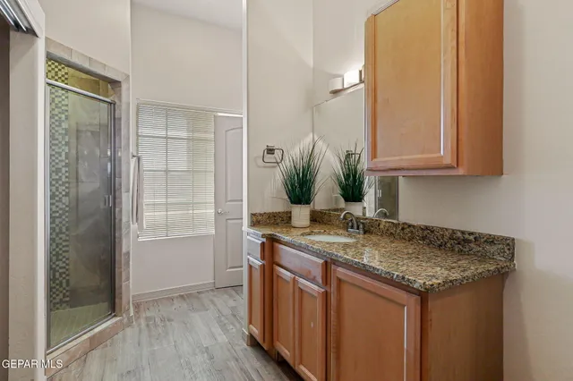 a bathroom with a granite countertop sink and a mirror