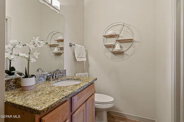 a bathroom with a granite countertop sink and a mirror