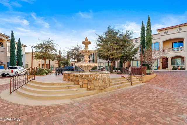 a view of a patio with table and chairs potted plants and large tree