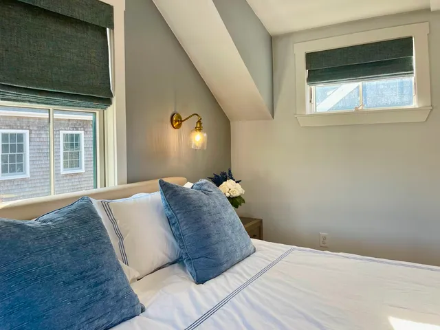 a bedroom with a bed and a large window