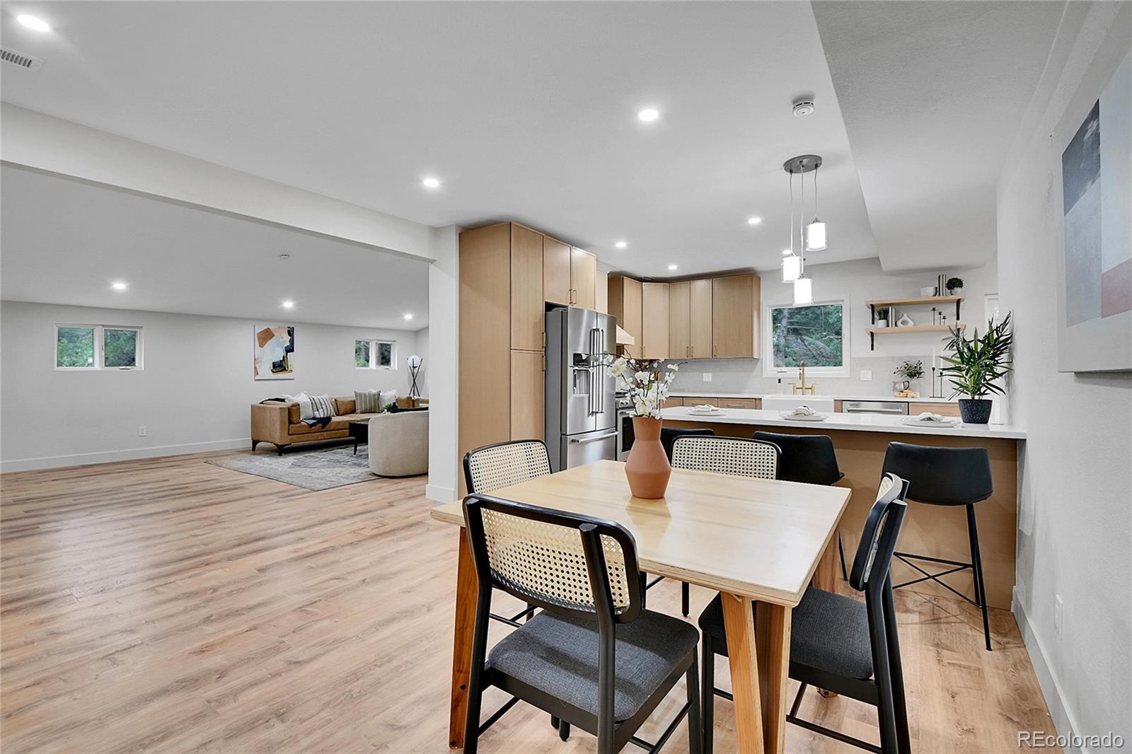 8919 South Hillview Road Morrison, CO 80465 - Photo 14 of 50 a kitchen with stainless steel appliances kitchen island granite countertop a kitchen island a stove a dining table and chairs with wooden floor