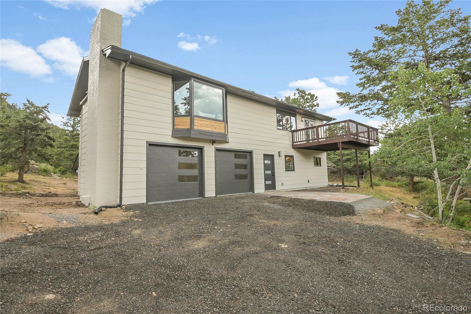 8919 South Hillview Road Morrison, CO 80465 - Photo 3 of 50 a front view of a house with a garage