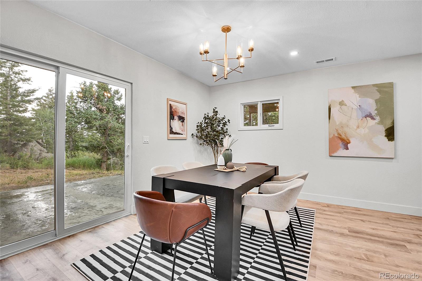 8919 South Hillview Road Morrison, CO 80465 - Photo 8 of 50 a dining room with wooden floor and a chandelier