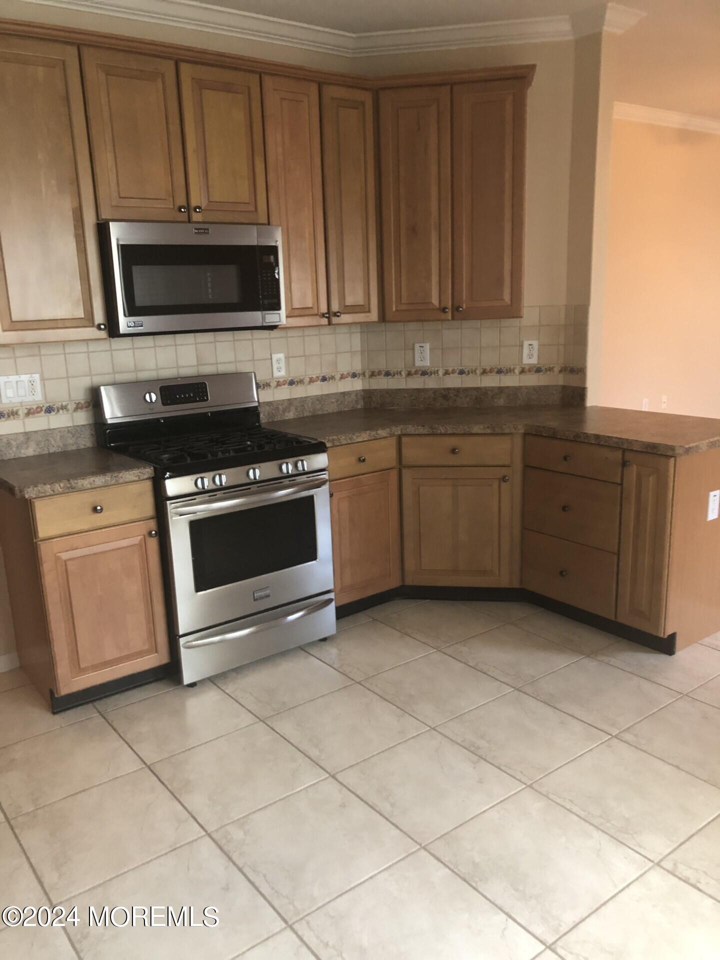 9 Modena Court Manchester Township, NJ 08759 - Photo 3 of 10 a kitchen with granite countertop a stove a sink and a microwave
