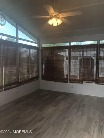 en empty room with wooden floor and windows