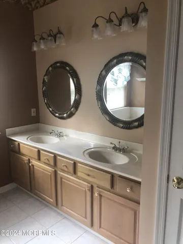 a bathroom with a granite countertop double vanity and a mirror