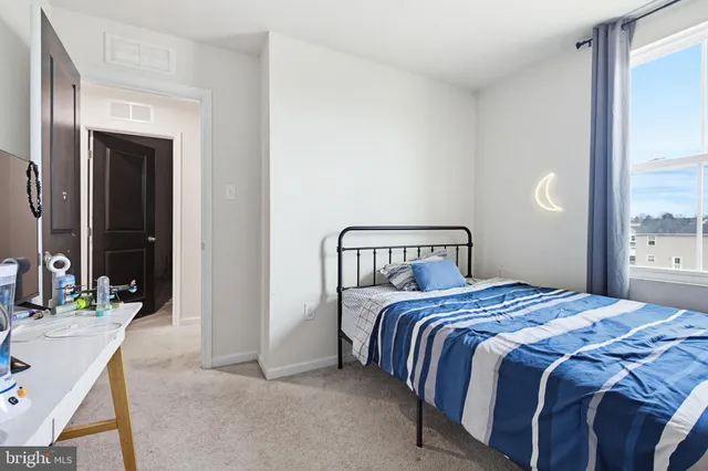 a bedroom with a bed a mirror and a window