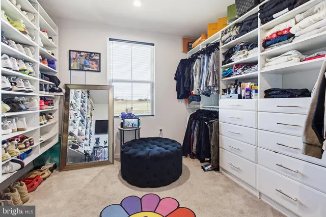 a view of walk in closet with clothes and shoes