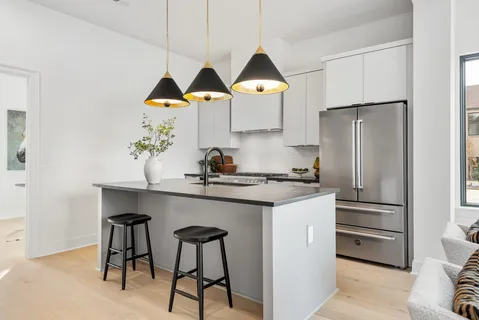 a kitchen with stainless steel appliances a sink a stove and a refrigerator