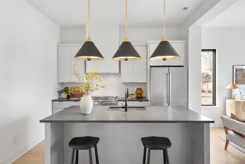 a kitchen with a sink a table and chairs in it