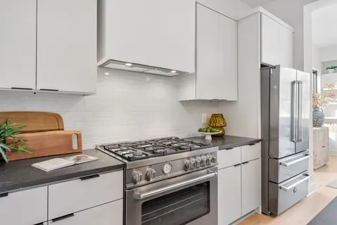 a kitchen with stainless steel appliances granite countertop a stove and a refrigerator