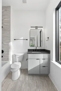 a bathroom with a toilet sink and mirror